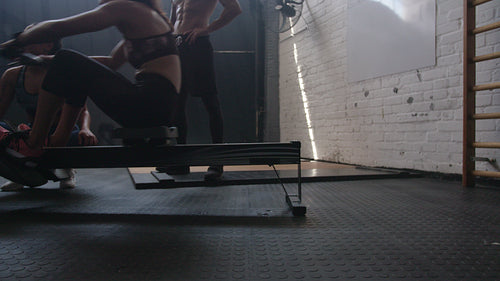 Woman training on row machine with trainers