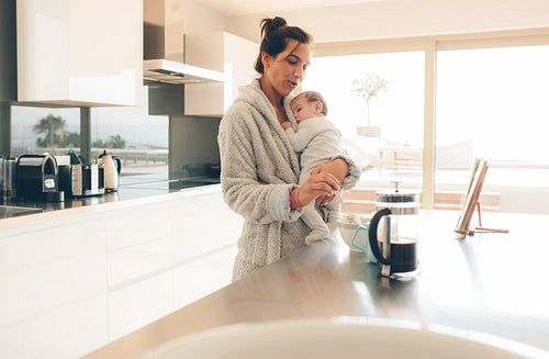 Woman with her son in kitchen making baby food