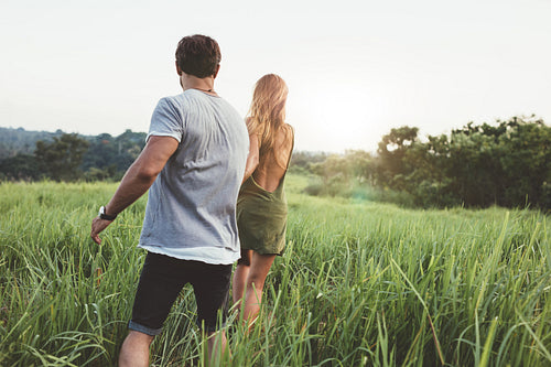 Young couple strolling in a grass field