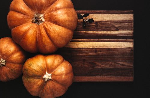 Halloween flat lay of pumpkins on wooden board