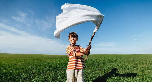 Boy waving white flag symbolizing peace