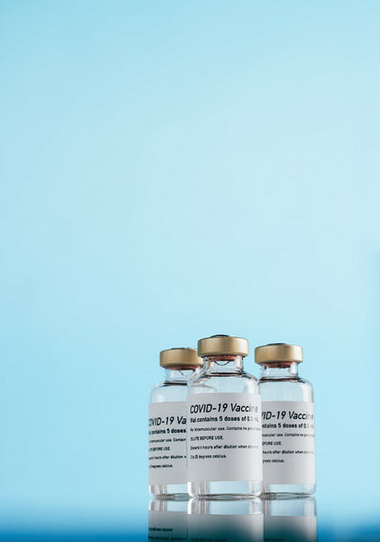 Covid-19 vaccine vials over blue background