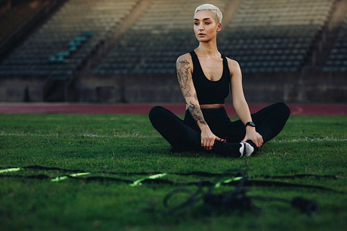 Female runner doing workout sitting in a stadium