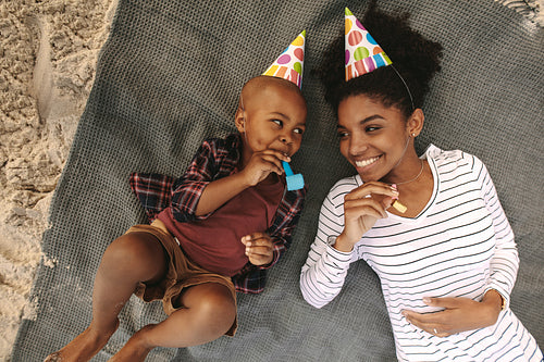 Mother and son blowing whistle and having fun at beach