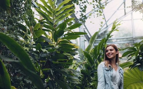 Smiling female standing in greenhouse