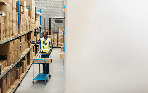 Warehouse order picker doing voice-directed picking with a headset on