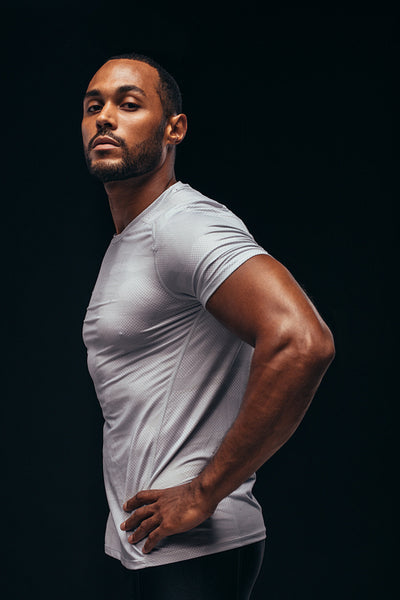 Side view portrait of a fit man on black background