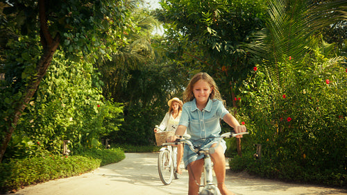 Mother and child enjoy a delightful bicycle ride at a luxurious tropical island resort