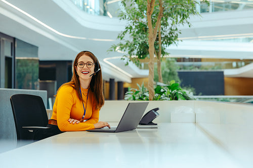 Receptionist in modern office environment with headset