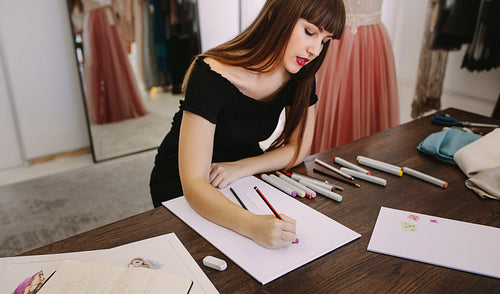 Fashion designer working on her designs in her studio