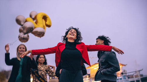 Group of joyful friends celebrating outdoors during a festive evening