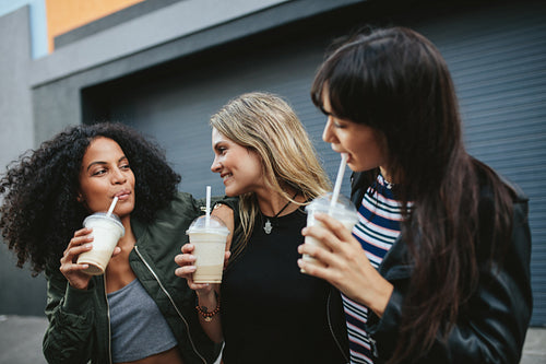 Group of female friends having ice coffee outdoors
