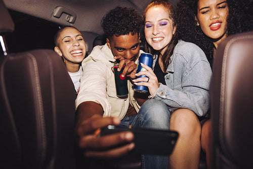 Friends taking a selfie inside a car at night