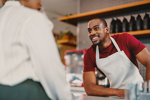Friendly barista engaging with customer in a modern coffee shop