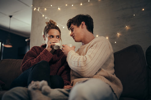 Couple relaxing on sofa having coffee