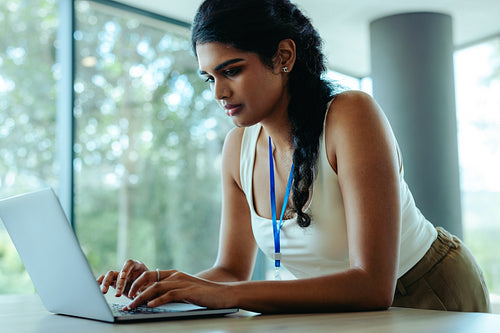 Indian professional working diligently on her laptop in an office