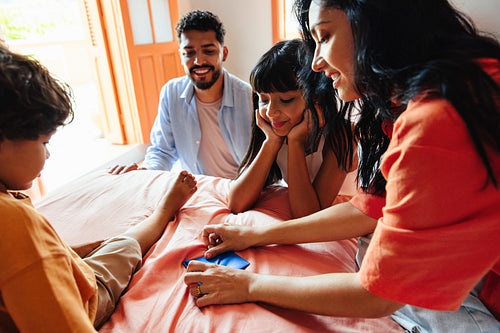 Latino family enjoying leisure time playing games together indoors