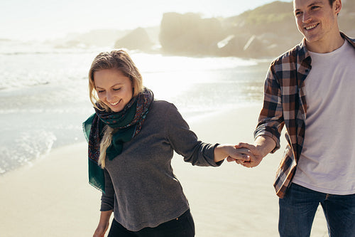 Couple walking on the beach holding hands