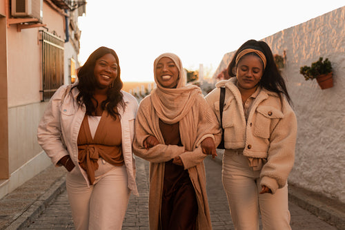 Cheerful friends smiling while walking together outdoors