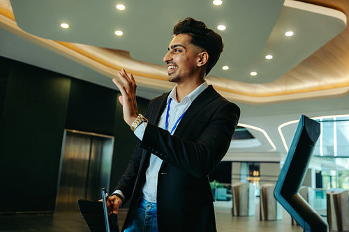 Corporate accountant greeting colleague in modern office lobby