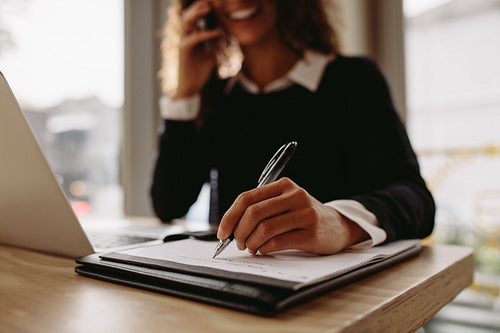 Woman making notes at cafe