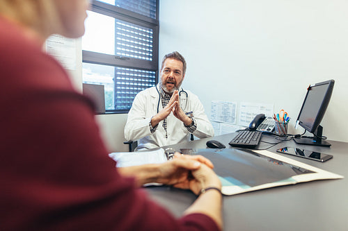 Doctor discussing with female patient in his clinic