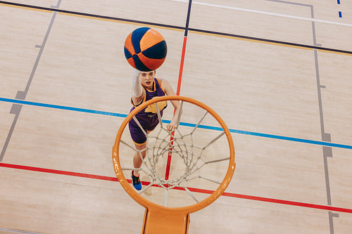 Young player scoring a basketball shot in an indoor court