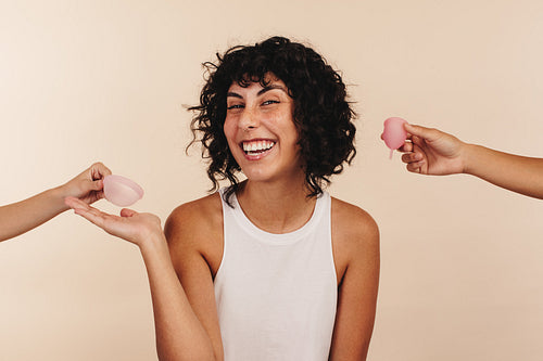 Happy young woman choosing a menstrual disc over a menstrual cup