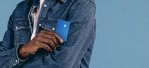 Paying with a credit card made easy: Man explores tap and go feature as he holds his bank card