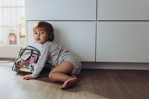 Kid sitting on floor with a bag