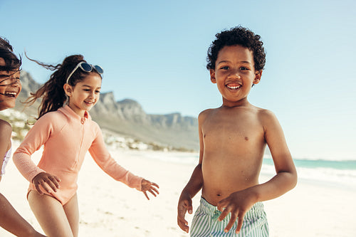 Cute little boy having fun with his friends at the beach