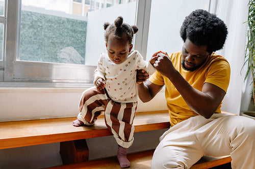 Father assisting toddler at home