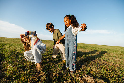 Joyful children playing together in a wide open field