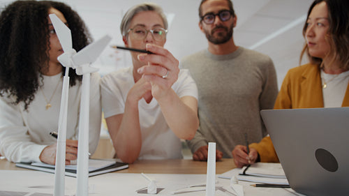 Brainstorming solutions for sustainable energy: Business team designing a wind turbine