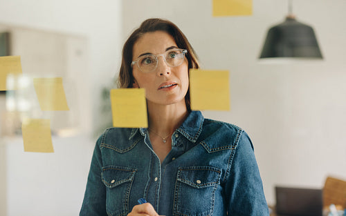 Creative strategies in the workplace: Businesswoman brainstorming with sticky notes