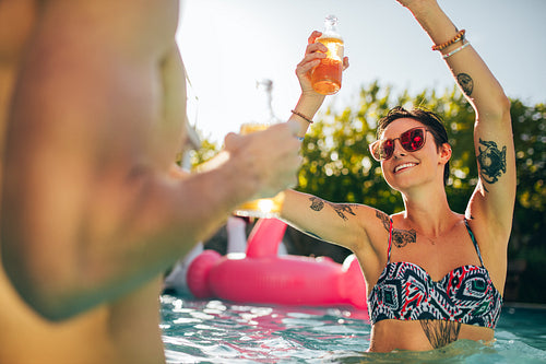 Woman partying with friends in swimming pool