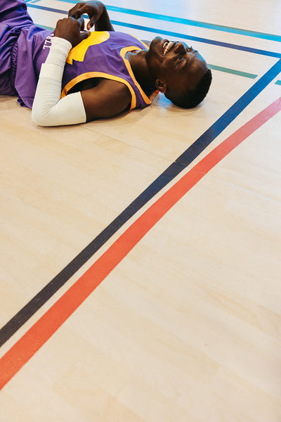 Exhausted basketball player lying on the court laughing after an intense game
