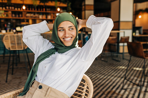 Pensive Muslim woman sitting in a cafe