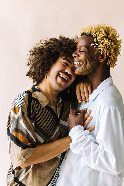 Carefree young gay couple embracing each other in a studio