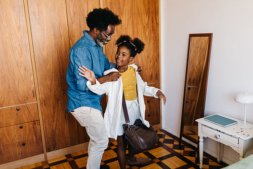 Mature man having a playful moment with his daughter after work