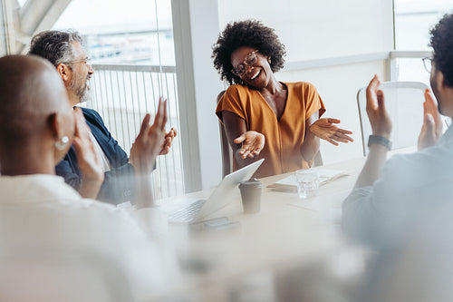 Successful business team applauding and celebrating their project in a diverse boardroom meeting