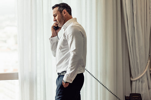 Businessman making call from hotel room