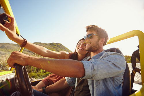 Woman taking selfie on road trip with man