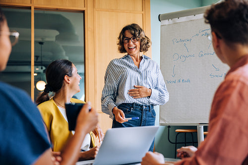 Businesswoman presenting ideas during a meeting to an engaged and diverse team