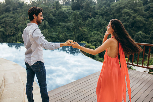 Caucasian couple dancing near swimming pool