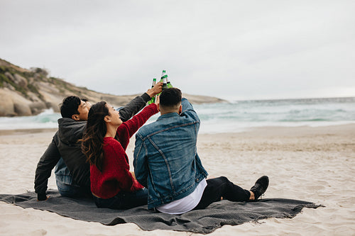 Friends on beach toasting beers