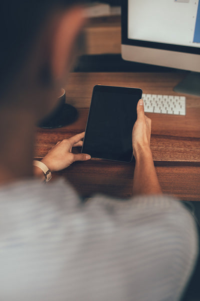 Woman sitting at her desk using digital tablet