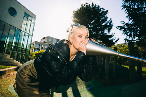 Woman speaks into a talking tube at playground