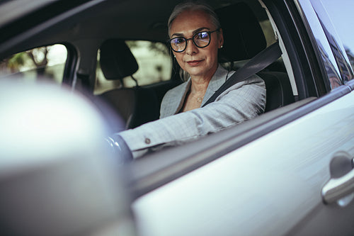 Senior businesswoman going to office in her car