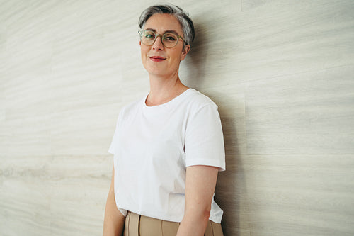 Female entrepreneur standing against a wall in an office